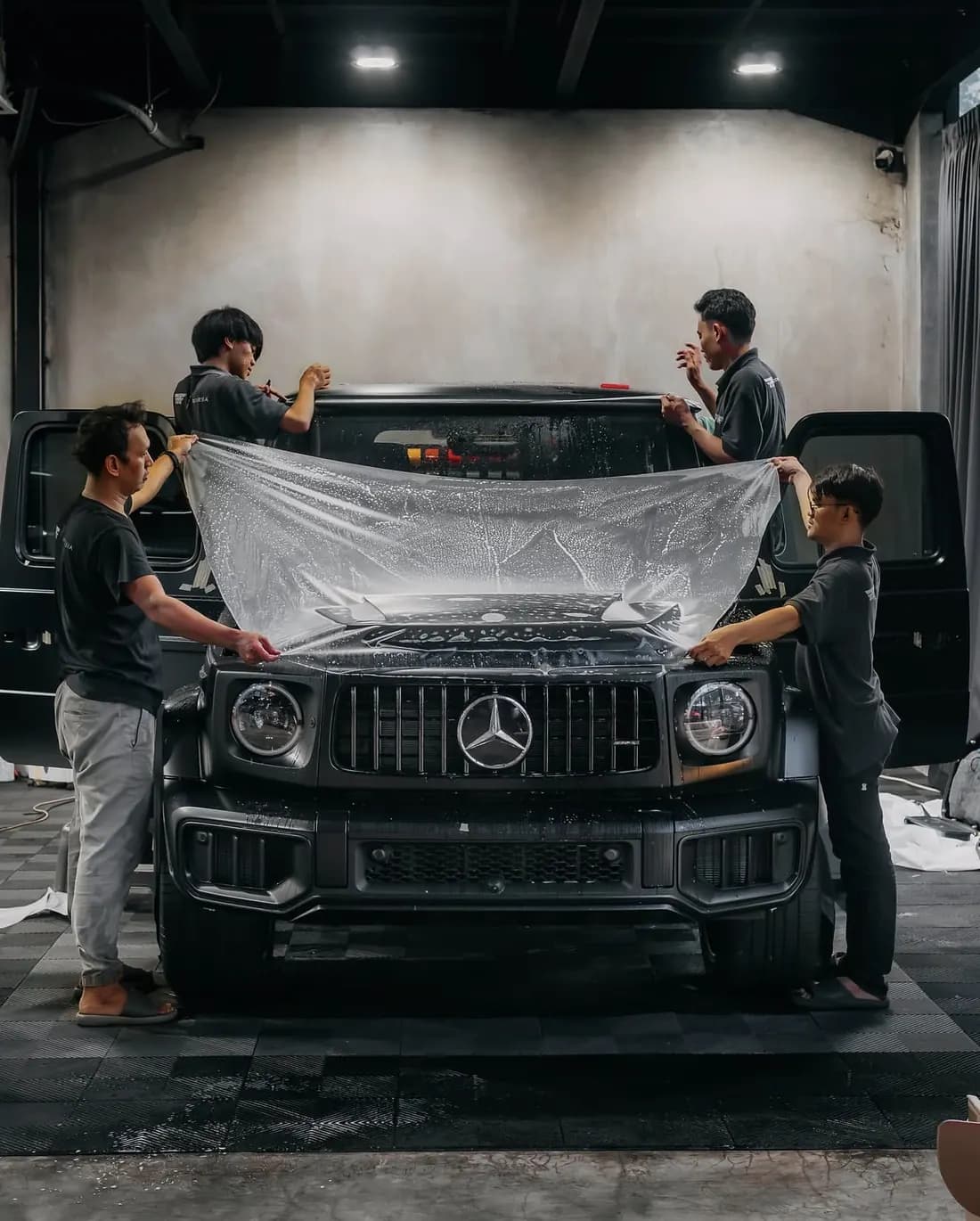 Equipe aplicando PPF no capô de um SUV